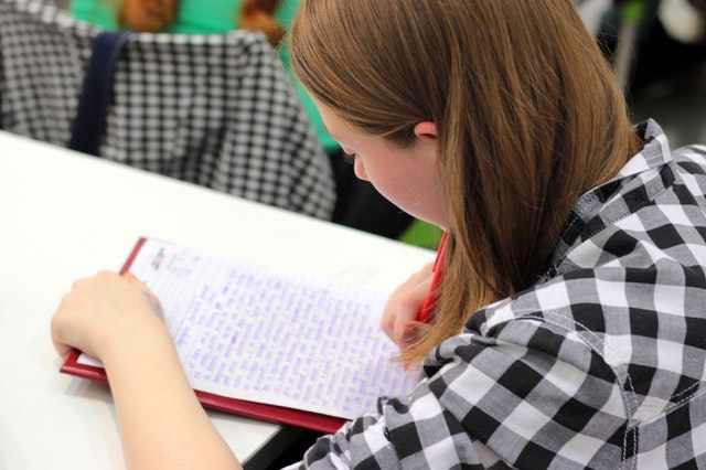 girl writing notes in class